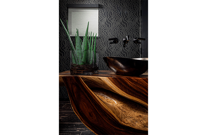 Designer Gina Bauerle turned this showstopping natural chamcha wood root table into a vanity in this powder bath.