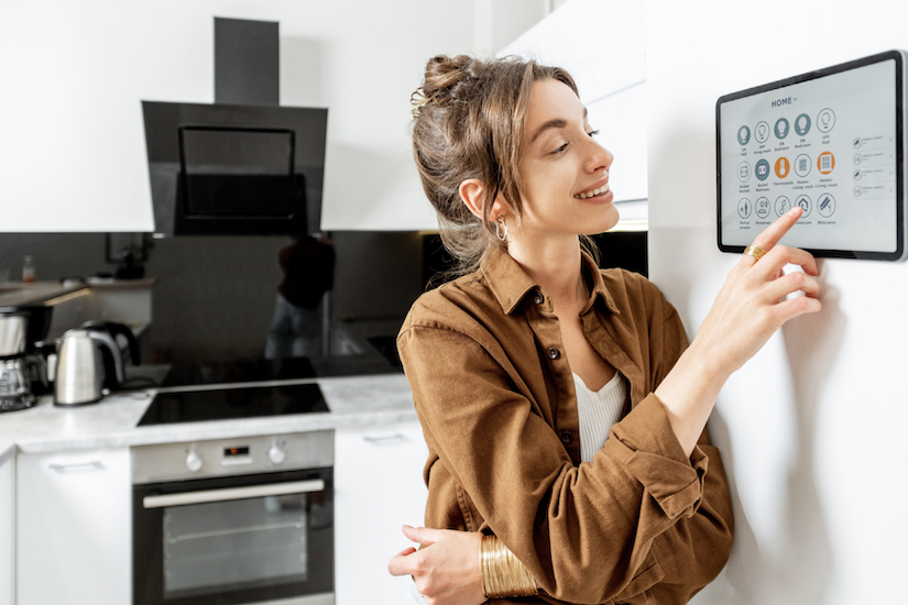 woman using smart home tech touchpad in kitchen