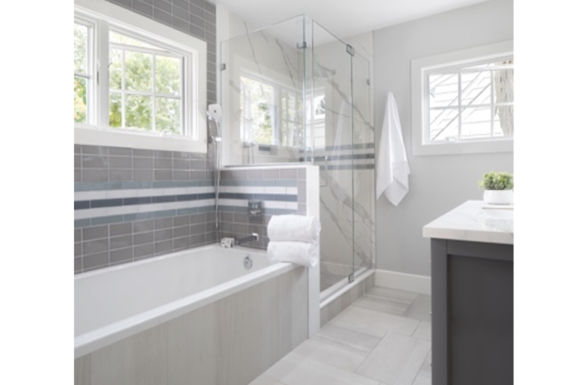 midsize primary bath with tub shower and windows in neutral colors