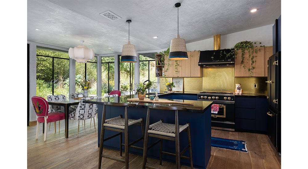 This Laurel Canyon home for the high-net-worth clients features a compact yet open kitchen with deep blue cabinets with brass accents and Anthropologie products throughout.