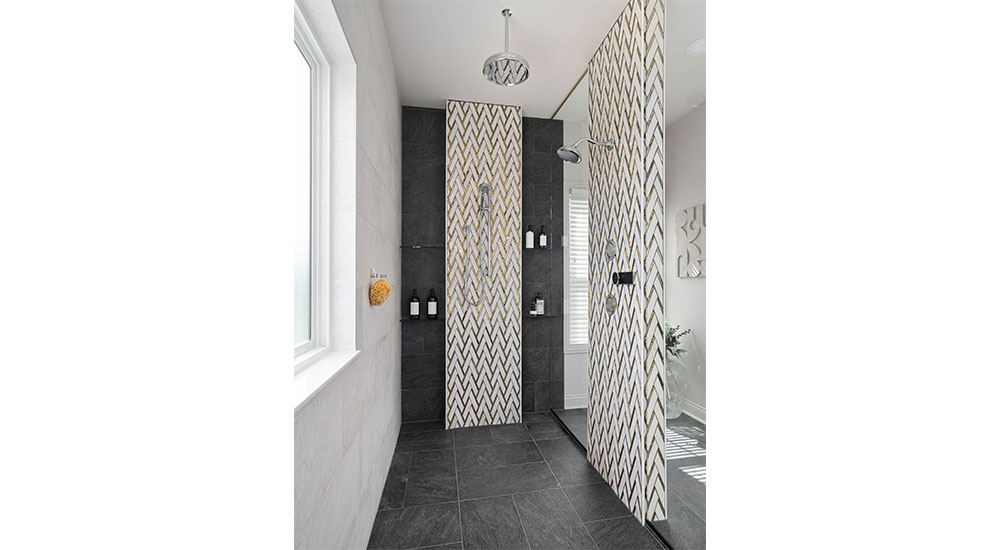 shower enclosure with black and gold chevron tile walls 