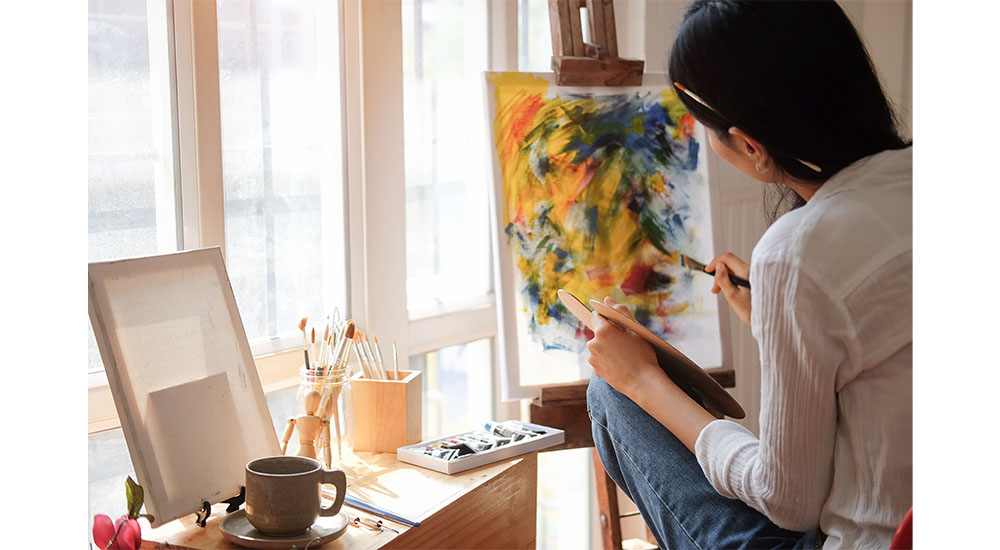 woman painting near window