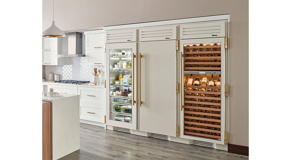 glass front wine refrigerator installed with other refrigerators in kitchen