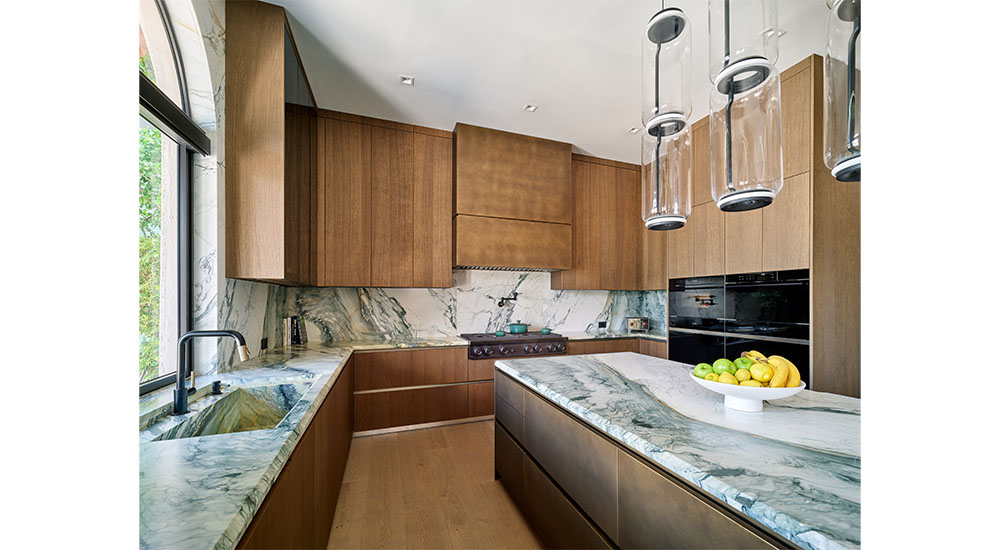 modern kitchen with wood cabinets and marble backsplash and island