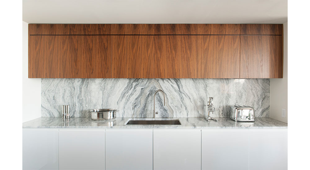 modern kitchen with marble backsplash and wood cabinets in chicago condo