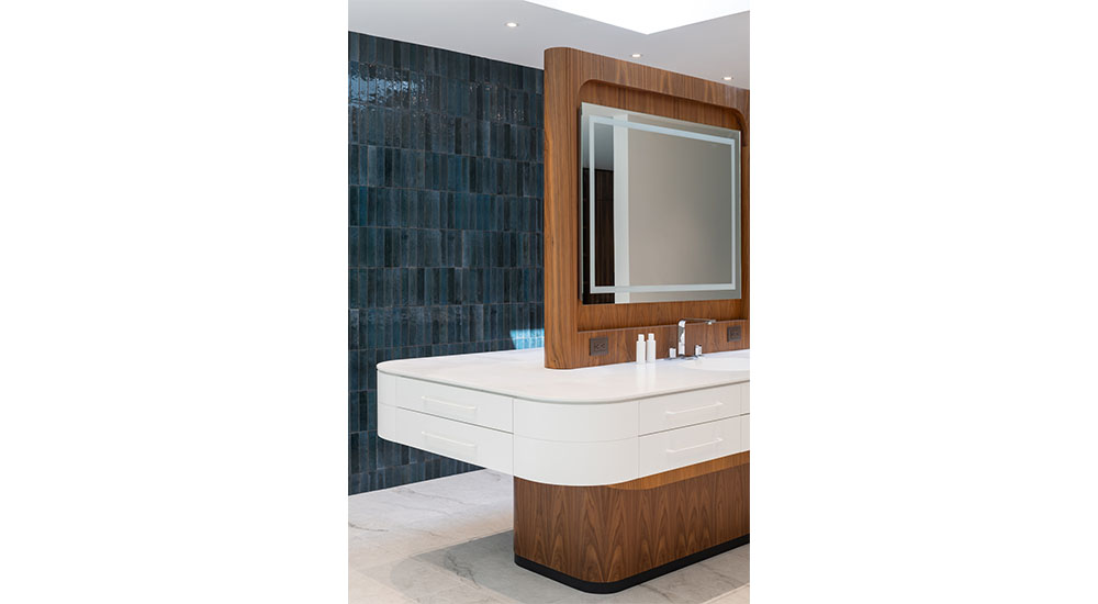 primary bathroom island with sink and mirror tile wall