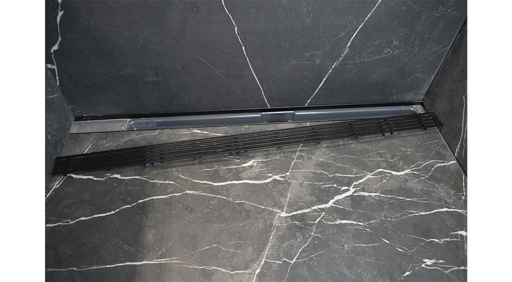 linear shower drain installed in gray stone floor universal design ada compliant