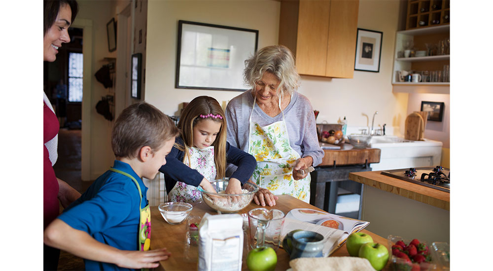 multi-generational kitchen with kids and older people making cookies