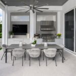 outdoor kitchen with grill, ceiling fan and dining table